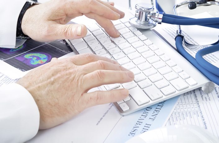 Male doctor writing on keyboard